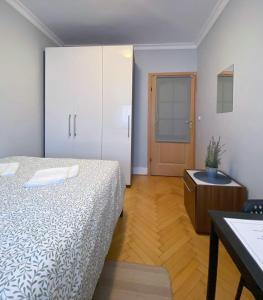 a bedroom with a bed and a cabinet and a table at HALBY rooms Nowolipki 15 in Warsaw