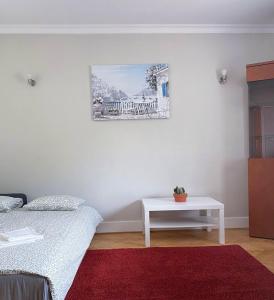 a bedroom with a white bed and a table at HALBY rooms Nowolipki 15 in Warsaw