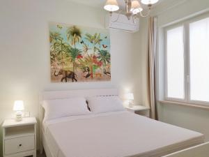 a bedroom with a white bed and a painting on the wall at Colleoni 19 Bangkok, appartamento superior in Civitanova Marche