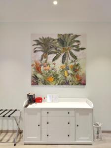 a painting of palm trees in a room with a white cabinet at Colleoni 19 Bangkok, appartamento superior in Civitanova Marche