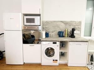 een keuken met een wasmachine en een magnetron bij Le Grand Cognet by iZiLi *Charme&Spacieux*Centre* in Châtellerault