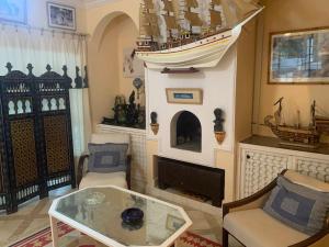 een woonkamer met een glazen tafel en een boot aan de muur bij Havre de paix en face de l'océan in Tanger
