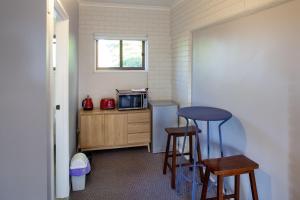 a small kitchen with two stools and a microwave at Treetops Silvan Valley Lodge - suite 3 in Silvan