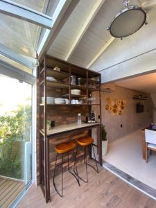 a kitchen with two stools and a bar in a room at Casa em Resort na Lagoa da Conceição in Florianópolis