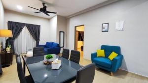 a living room with a dining table and blue chairs at A ONE Holiday Apartment in Tanah Rata
