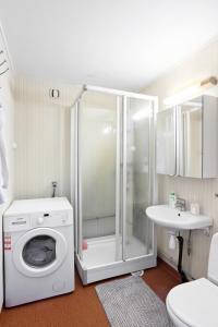 uma casa de banho com uma máquina de lavar roupa e um lavatório em Sentralt og romslig leilighet em Drammen