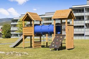 a playground with a blue slide and a slideintend at Sentralt og romslig leilighet in Drammen