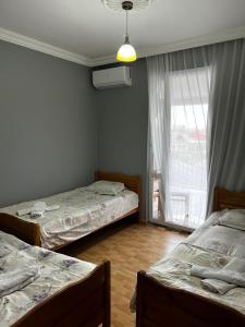 a bedroom with two beds and a window with a view at ECO HOUSE in K'obulet'i