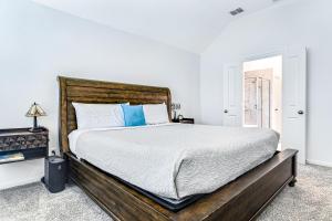 a bedroom with a large bed with a wooden headboard at Coronilla Bend - Main Home in Austin