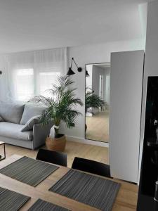 sala de estar con sofá y espejo en MALECON 47 Apartamento reformado en primera linea, en Muxía