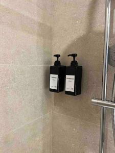 dos botellas de jabón sentadas en la pared de una ducha en MALECON 47 Apartamento reformado en primera linea, en Muxía