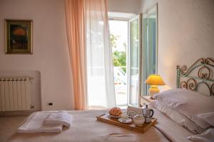 a bedroom with a bed with a tray of food on it at Hotel Sunset Green in Ischia