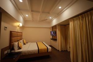 a bedroom with a bed and a ceiling at Hotel Grand Sabarees in Madurai