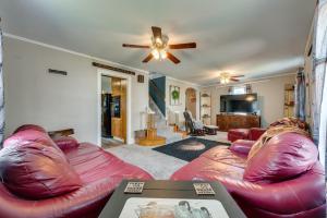 uma sala de estar com mobiliário de couro vermelho e uma ventoinha de tecto em Cozy Iowa Getaway with Patio and Fenced-In Yard! em Dyersville