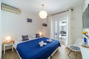 a bedroom with a blue bed with two towels on it at Rooms Anna in Milna