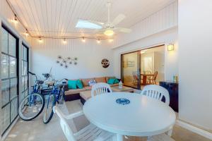 a dining room with a white table and a bike at Villas of Bethany West - 792B Salt Pond Circle in Bethany Beach