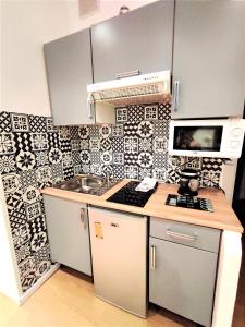 a small kitchen with a stove and a microwave at joli studio dans maison niçoise in Nice