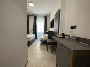 Habitación de hotel con 1 dormitorio con cama y escritorio en Dolmen Guest House, en Alghero