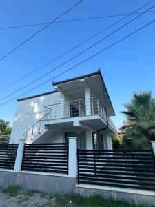 a white house with stairs and a palm tree at Residence Mary in Velipojë +14 photos