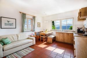 een woonkamer met een bank en een keuken bij Weingut Lieselehof Apt Aurora in Caldaro