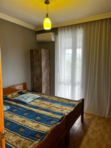 a bedroom with a large bed with a window at ECO HOUSE in K'obulet'i