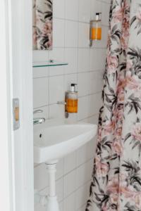 a bathroom with a sink and a shower curtain at Slottsparken Motel in Huskvarna