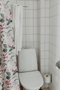 a bathroom with a toilet and a shower curtain at Slottsparken Motel in Huskvarna +15 photos
