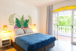 um quarto com uma cama com um edredão azul em Sea Wolf Hostel - Lagoa da Conceição em Florianópolis
