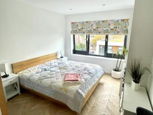 a bedroom with a bed and a window at Cosy 1 bedroom apartment with balcony near Chiswick in London