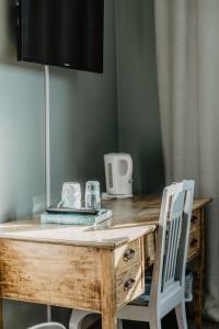 a wooden desk with a mirror and a chair at Slottsparken Motel in Huskvarna