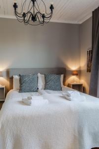 a bedroom with a large white bed with two dishes on it at Slottsparken Motel in Huskvarna