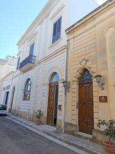 ein Gebäude mit zwei Holztüren auf einer Straße in der Unterkunft Palazzo Giordano Luxury Rooms in Squinzano