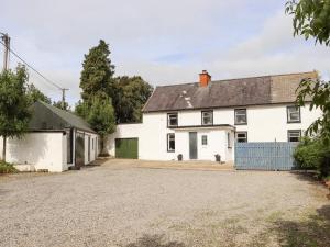 an image of a white house with a driveway at An Grianan in Ballynabola