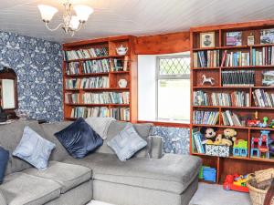 uma sala de estar com um sofá e prateleiras de livros em An Grianan em Ballynabola