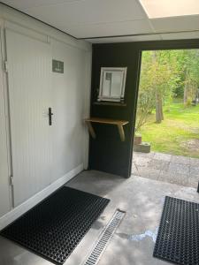 un garaje con una puerta y un espejo. en Glamplodge met privé sanitair, en Blesdijke