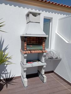 um forno de tijolo sentado em cima de um pátio em Moliceiros Torreira em Torreira