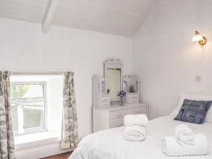 a white bedroom with a bed and a window at An Grianan in Ballynabola