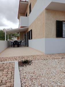 a patio of a house with a table on it at Farfalla in Vila do Maio