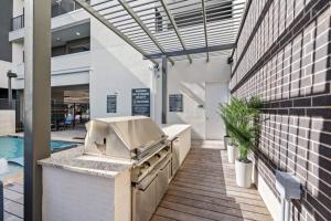 a outdoor kitchen with a grill and a pool at Luxurious 1BD apt in Austin suburb in Pflugerville