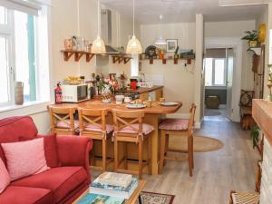 a kitchen and living room with a table and chairs at Kevin's Cottage in Glenawilling