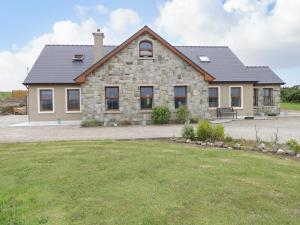 a stone house with a large yard in front of it at Tallagh Road in Tallagh