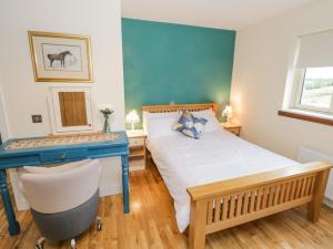 una camera con letto e scrivania blu di The Derries a Mullaghoran