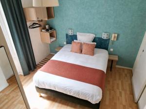 een slaapkamer met een groot bed met 2 kussens erop bij Hôtel les Platanes in Villeneuve-sur-Lot