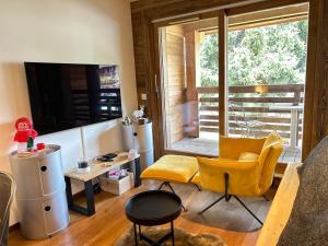 ein Wohnzimmer mit gelben Stühlen und einem großen Fenster in der Unterkunft Studio Les Gets, 1 pièce, 4 personnes - FR-1-623-34 in Les Gets