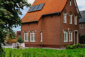 une maison avec des panneaux solaires sur le toit dans l'établissement Vakantiewoning 't Hovenshuis, à Kinrooi