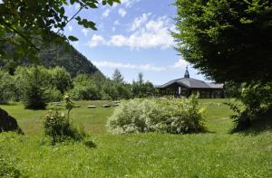 a field of green grass with a building in the background at Domaine d'Avallon - petit Tibet au coeur des Alpes in Arvillard