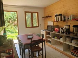 a kitchen with a table and a stove and a table and chairs at Domaine d'Avallon - petit Tibet au coeur des Alpes in Arvillard