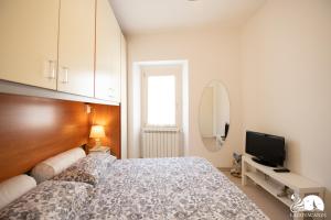 een slaapkamer met een bed en een flatscreen-tv bij La Colomba in San Felice del Benaco