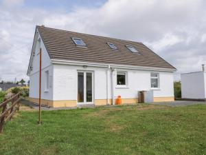 una casa blanca con techo negro en Kincasslagh en Gortnasate