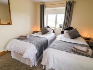 dwa łóżka w pokoju z oknem w obiekcie Kincasslagh w mieście Gortnasate